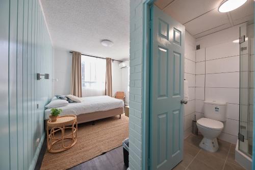 a bathroom with a bed and a toilet in a room at Little Coogee Hotel in Sydney