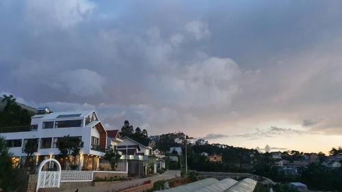 a white house on a hill with the sunset at Nhà Sói Homestay Da Lat in Da Lat
