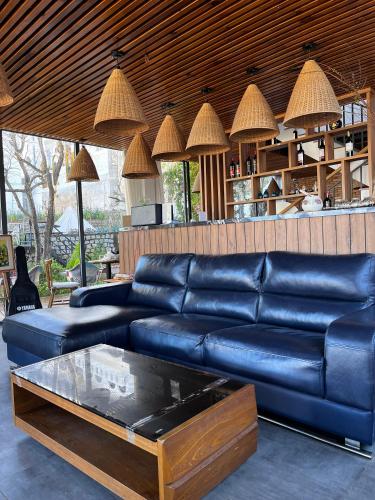 a living room with a blue leather couch and a coffee table at Nhà Sói Homestay Da Lat in Da Lat