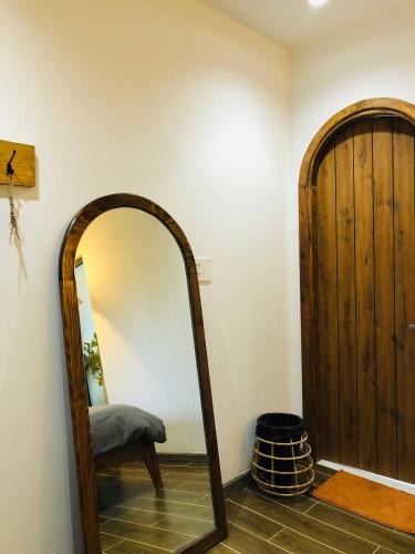 a mirror in a room with a wooden door at Nhà Sói Homestay Da Lat in Da Lat