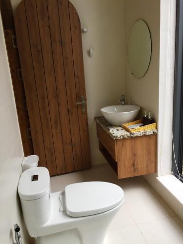a bathroom with a toilet and a sink and a mirror at Nhà Sói Homestay Da Lat in Da Lat