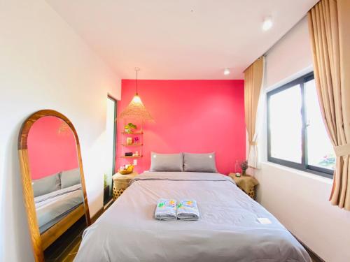 a bedroom with a large bed with a pink wall at Nhà Sói Homestay Da Lat in Da Lat