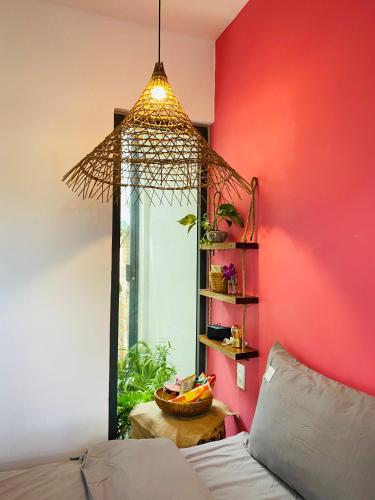 a room with a bed and a red wall at Nhà Sói Homestay Da Lat in Da Lat
