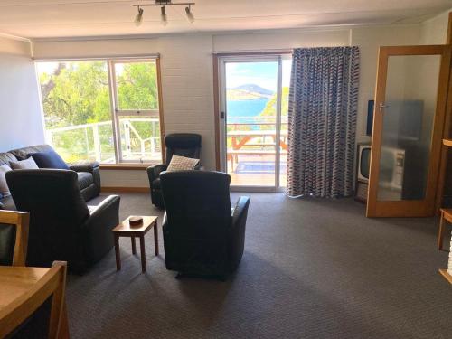 a living room with chairs and a large window at Coningham Beach House in Coningham