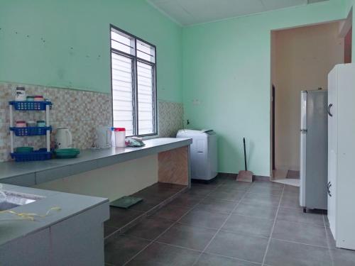 a kitchen with a sink and a refrigerator at Homestay Wan Z in Kuala Terengganu