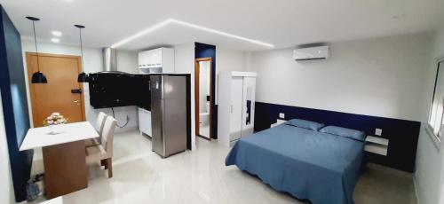 a bedroom with a blue bed and a television at FLAT 22º andar totalmente mobiliado lazer completo in Guarulhos