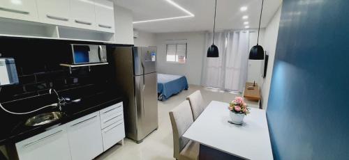 cocina con mesa y habitación con cama en FLAT 22º andar totalmente mobiliado lazer completo, en Guarulhos