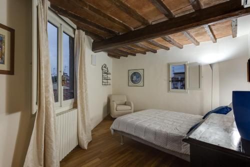 フィレンツェにあるApartments Florence - Vigna Nuova Albertiのベッドルーム1室(ベッド1台、椅子、窓付)