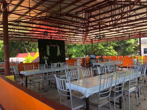 a group of tables and chairs under a roof at El Krimphoff Resort in Romblon