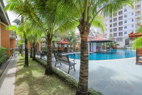 a group of palm trees next to a swimming pool at Sea Breeze Hotel & Villa in Sihanoukville