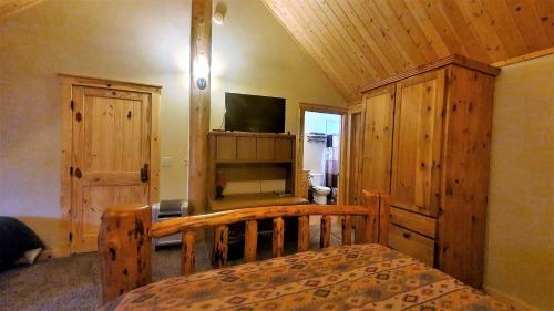 a bedroom with a bed and a tv in a room at Teton Hostel HideAway in Driggs