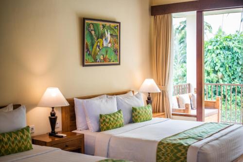 a hotel room with two beds and a balcony at Swahita Ubud in Ubud
