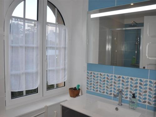 uma casa de banho com um lavatório e um espelho em Maison Perros-Guirec, 4 pièces, 5 personnes - FR-1-368-42 em Perros-Guirec