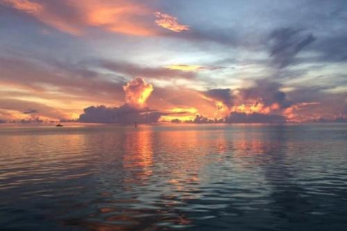 a sunset over a body of water at Cottage Miti Reva in Haapiti