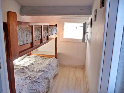 une petite chambre avec deux lits superposés et une fenêtre dans l'établissement Charmante Maisonnette avec Piscine près de la Plage, Parking, et Animaux Acceptés - FR-1-387-103, à Marseillan