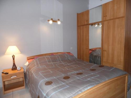 une chambre avec un lit, une commode et un miroir dans l'établissement Appartement 2 pièces avec mezzanine, terrasse et piscine à Marseillan-Plage - FR-1-326-528, à Marseillan