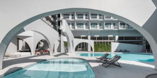 Außenansicht eines Hotels mit Schwimmbad in der Unterkunft Terra Nara in Pattaya