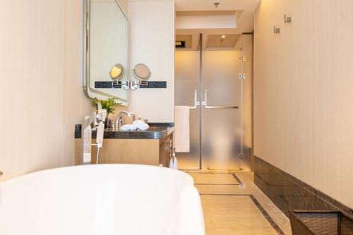 bagno con lavandino e specchio di Jingling Grand Hotel Gaochun a Gaochun