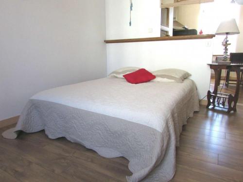 ein Schlafzimmer mit einem Bett mit einem roten Kissen darauf in der Unterkunft Studio Étel, 1 pièce, 2 personnes - FR-1-479-93 in Étel
