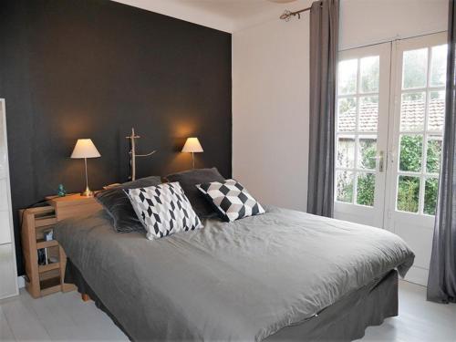 a bedroom with a bed with two pillows on it at Villa Landaise Rénovée Proche Plages - Jardin et Terrasse Privatifs - FR-1-413-80 in Capbreton