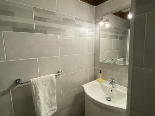 une salle de bain blanche avec un lavabo et un miroir dans l'établissement Maison Cosy à Capbreton: Proche Plage, Piscine Commune, Terrasse & Parking Sécurisé - FR-1-413-124, à Capbreton