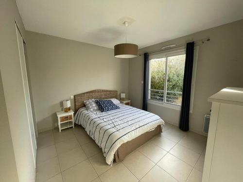 une chambre avec un lit et une grande fenêtre dans l'établissement Appartement cosy à Capbreton: Jardin, Terrasse, Parking, Wi-Fi, à 300m de la Plage - FR-1-413-133, à Capbreton