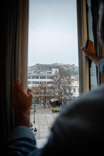 a person looking out of a window at a city at The Zillers Boutique Hotel in Athens