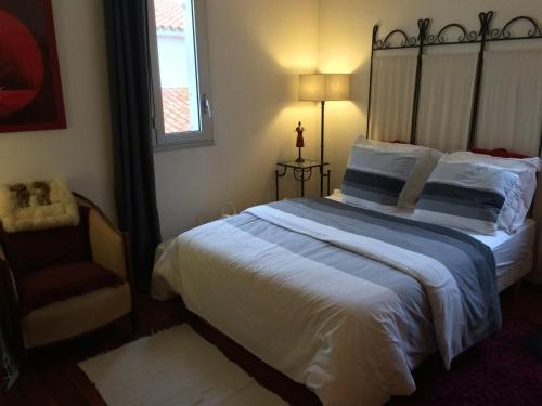 une chambre avec un grand lit et une chaise dans l'établissement Appartement 4 personnes proche centre ville de Royan avec terrasse et parking privé - FR-1-494-88, à Royan