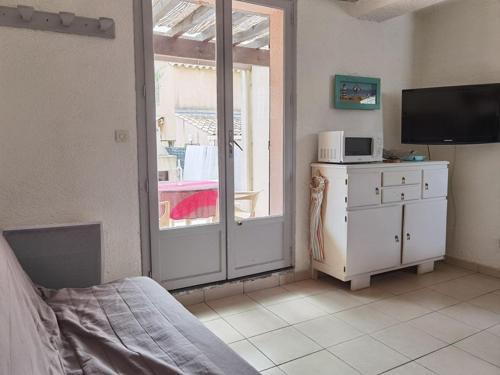Cette chambre comprend un lit, une télévision et une fenêtre. dans l'établissement Appartement 3 pièces, 6 couchages avec terrasse et parking privé, proche de la plage à Marseillan - FR-1-326-697, à Marseillan