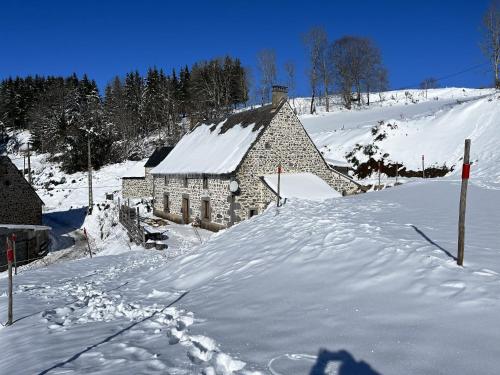 a stone building in the snow in front at Maison de campagne spacieuse a Chastreix avec cheminee in Chastreix