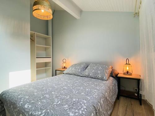 een slaapkamer met een bed met 2 nachtkastjes en 2 lampen bij Villa Capbreton, 3 pièces, 4 personnes - FR-1-413-174 in Capbreton