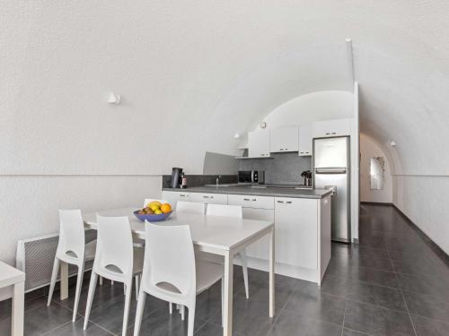 - une cuisine avec une table blanche et des chaises blanches dans l'établissement Duplex 3 pièces à Marseillan, 2 chambres, 6 pers, proche plage - FR-1-326-739, à Marseillan