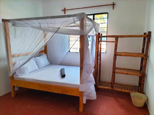a bedroom with two bunk beds with a remote control at Mambo Leo Hostel in Paje