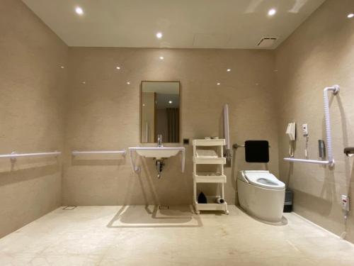 a bathroom with a sink and a toilet and a mirror at The Tango Hotel Taipei XinYi in Taipei