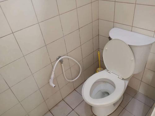 a small bathroom with a toilet with a hose at Alabang Condotel in Manila
