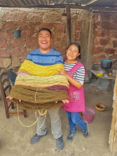 a man and a woman holding a blanket at LÍZU Tu casa en un pueblo zapoteca in Teotitlán del Valle