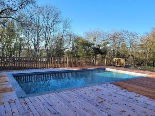 - une piscine à côté d'une clôture en bois dans l'établissement Domaine de la Falaise, à Saint-Hélen