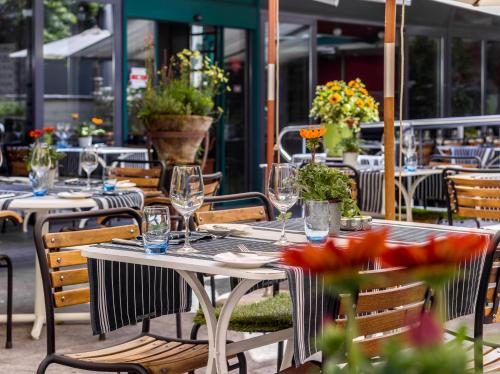 a table with glasses and flowers on a patio at Hotel Hofgarten Luzern in Luzern