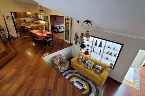 a living room with a yellow couch and a table at Excepcional Villa dulce Raquel chimenea y horno in Cuenca