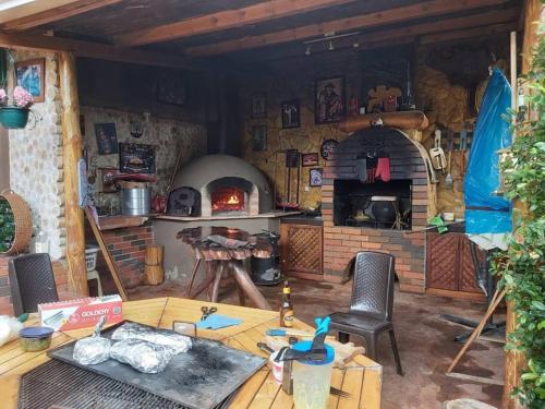 uma cozinha com um forno de tijolo, uma mesa e cadeiras em Excepcional Villa dulce Raquel chimenea y horno em Cuenca