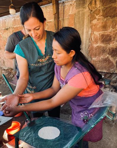 two women are working on a table with a woman at LÍZU Tu casa en un pueblo zapoteca in Teotitlán del Valle