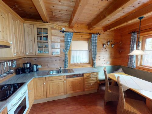 a kitchen with wooden cabinets and a table in a cabin at Chalet in Wildkogel near Ski Slopes & Pool in Neukirchen am Großvenediger
