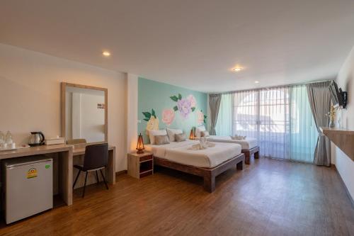 1 Schlafzimmer mit 2 Betten, einem Schreibtisch und einem Spiegel in der Unterkunft B House Chiang Mai Thailand in Chiang Mai