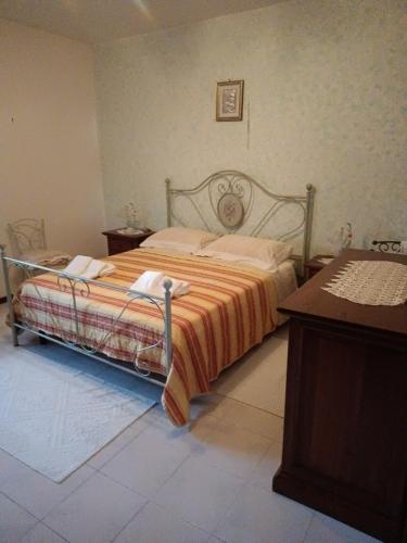 a bedroom with a bed with an orange comforter at Casa vacanze in Berchidda
