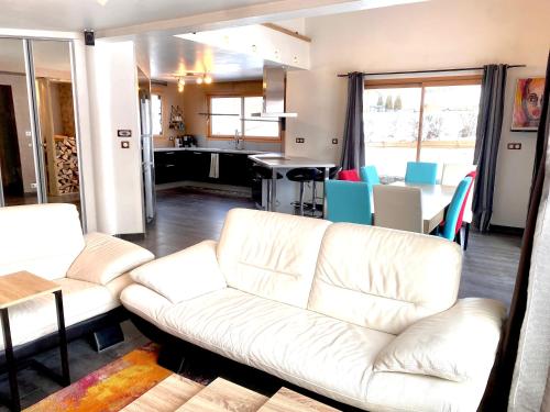 a living room with a white couch and a table at Maison chaleureuse au cœur du massif Jurassien in Saint-Pierre