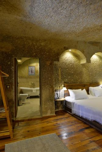 a bedroom with a large bed and a bathroom at Goreme Suites by AZA in Göreme