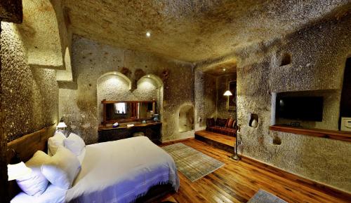 a bedroom with a bed and a television in a room at Goreme Suites by AZA in Göreme