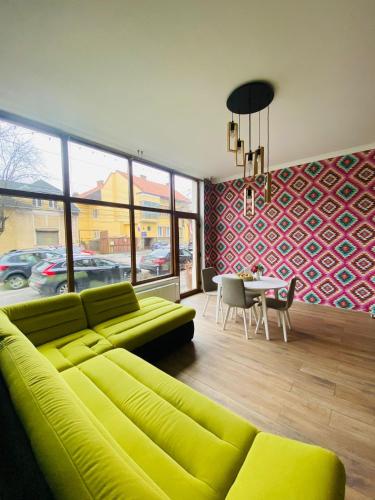 a living room with a green couch and a table at Hanul Fullton in Cluj-Napoca