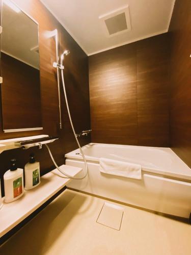 a bathroom with a bath tub and a sink at Ryokan Sawaya Honten in Kyoto