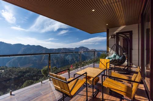 a balcony with a table and chairs and a view at The Manor Luxury Apartments, Shimla in Mashobra